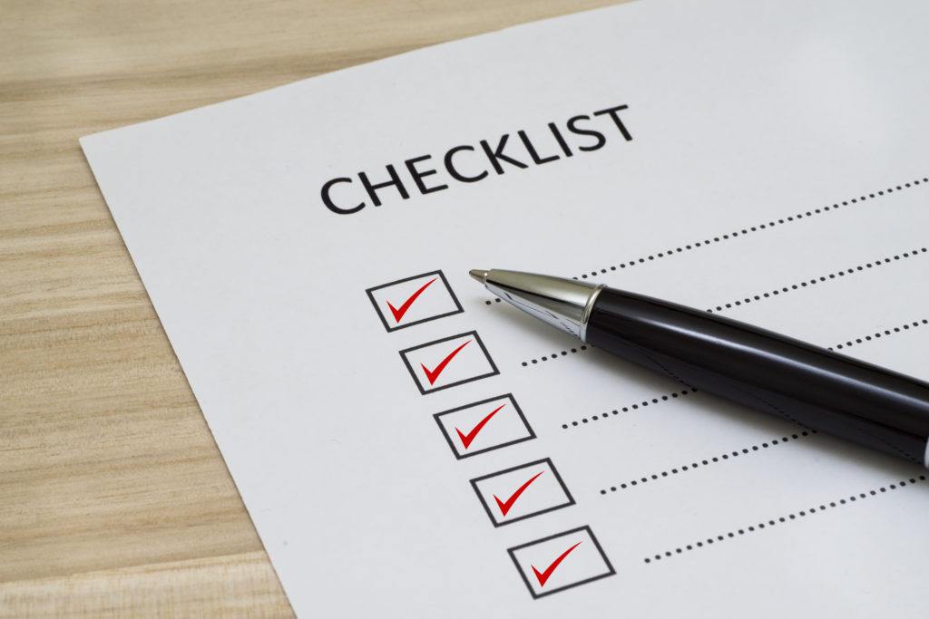 paper checklist with pen and checkboxes filled with red check marks